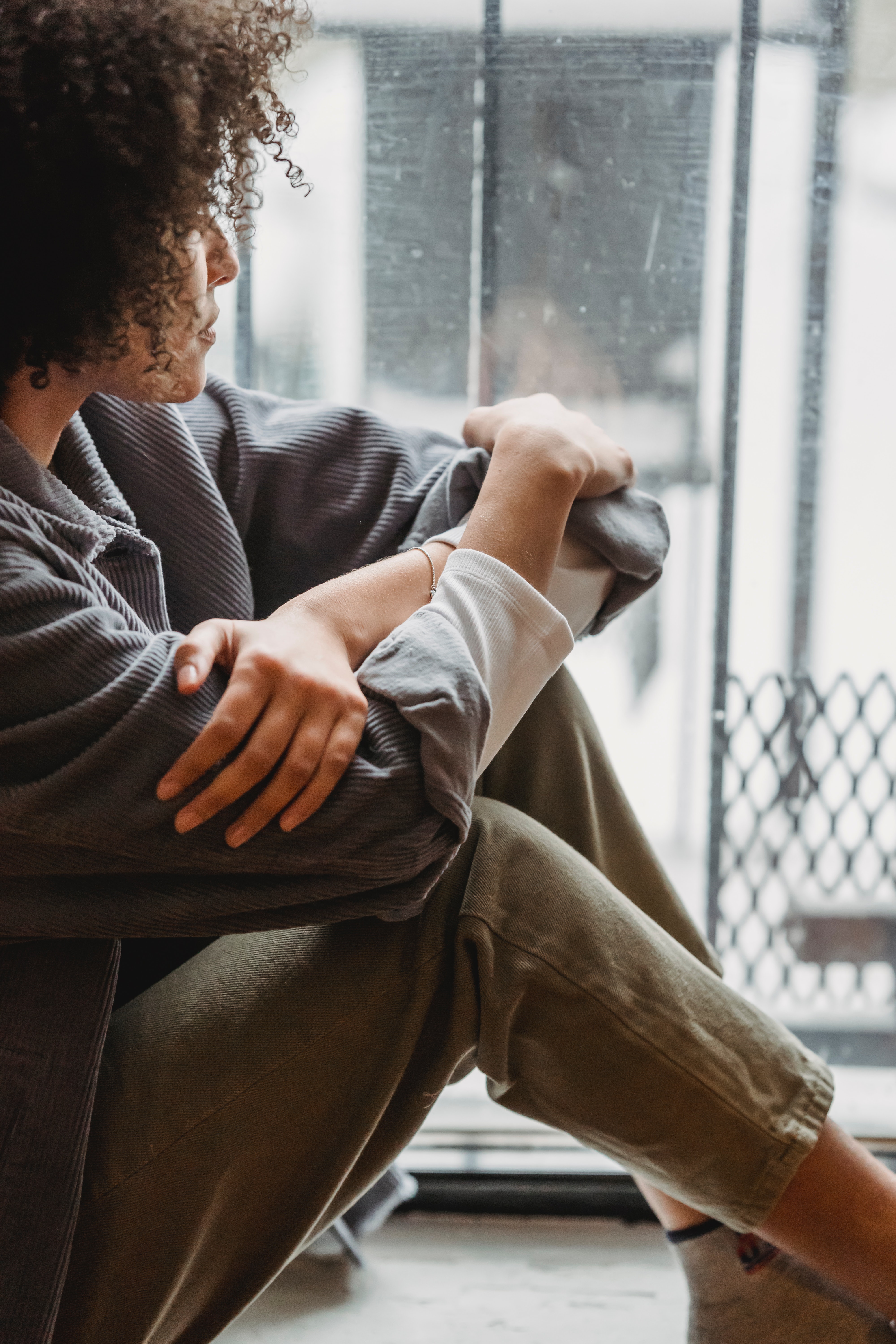 Tired woman sitting on floor looking out of window