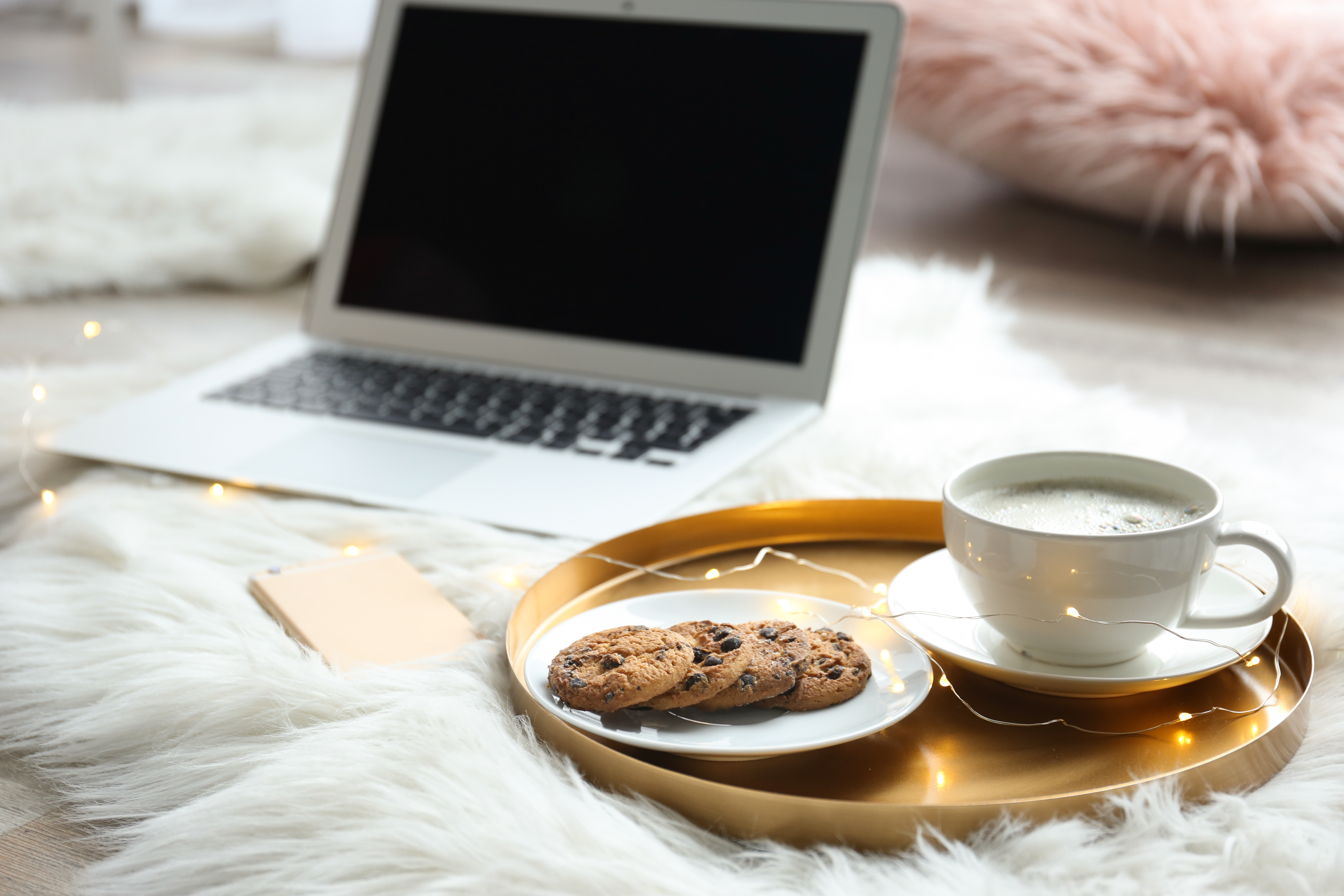 laptop on table with cookies and coffee on tray