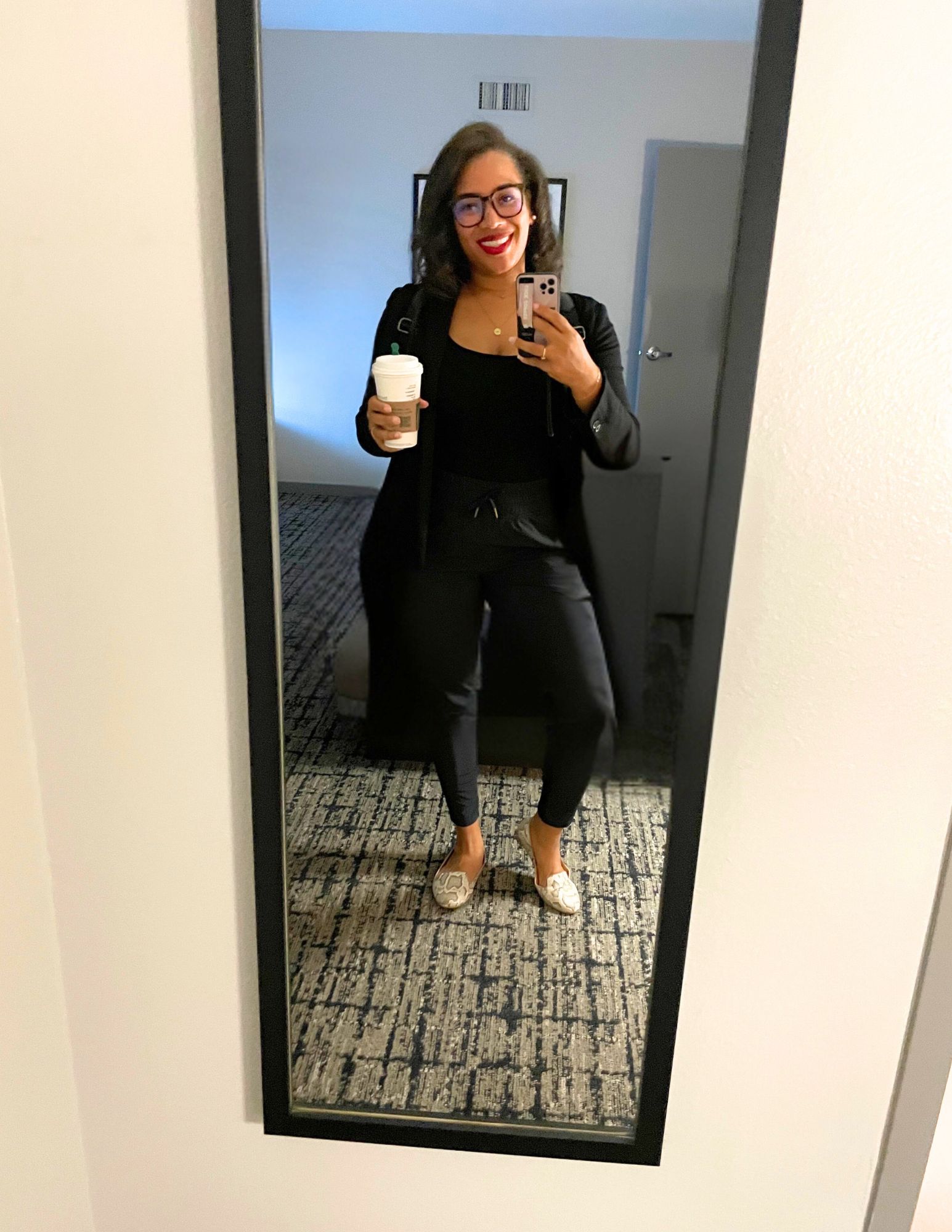 Sha Lekoe holding coffee taking selfie in conference hotel mirror