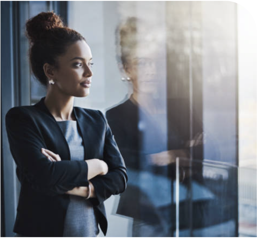 Business Woman looking out of window and seeing the city and her reflection.