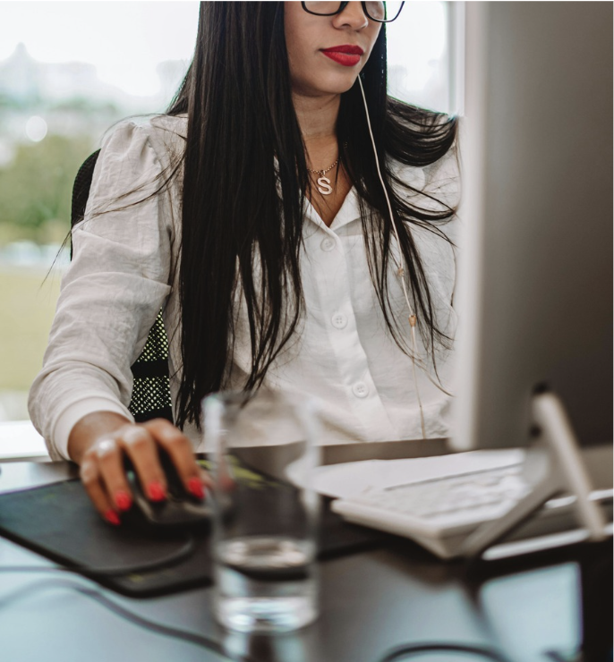 Business woman sitting at desk working on computer.